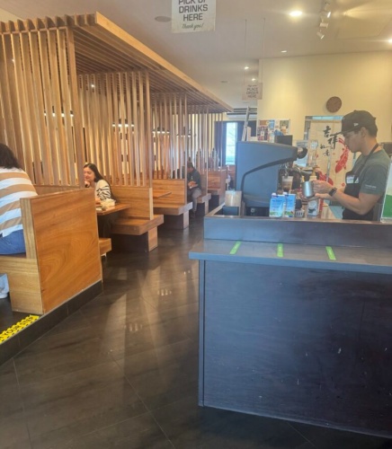 Infusion Tumon interior showing two-top tables and booths